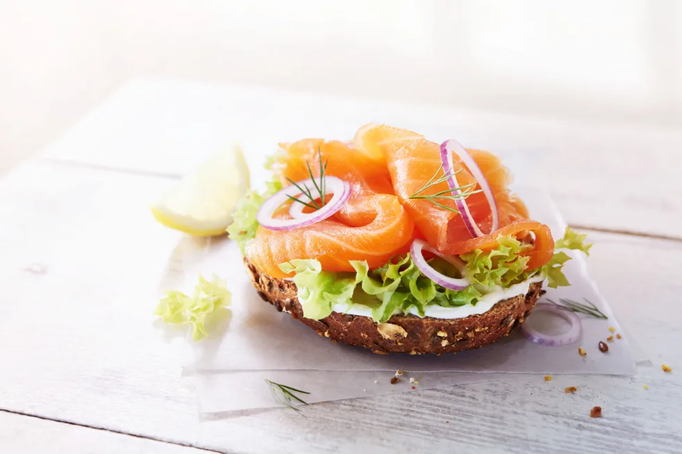 Modernes, helles, werbliches Foodfoto eines Lachs-Brötchens
